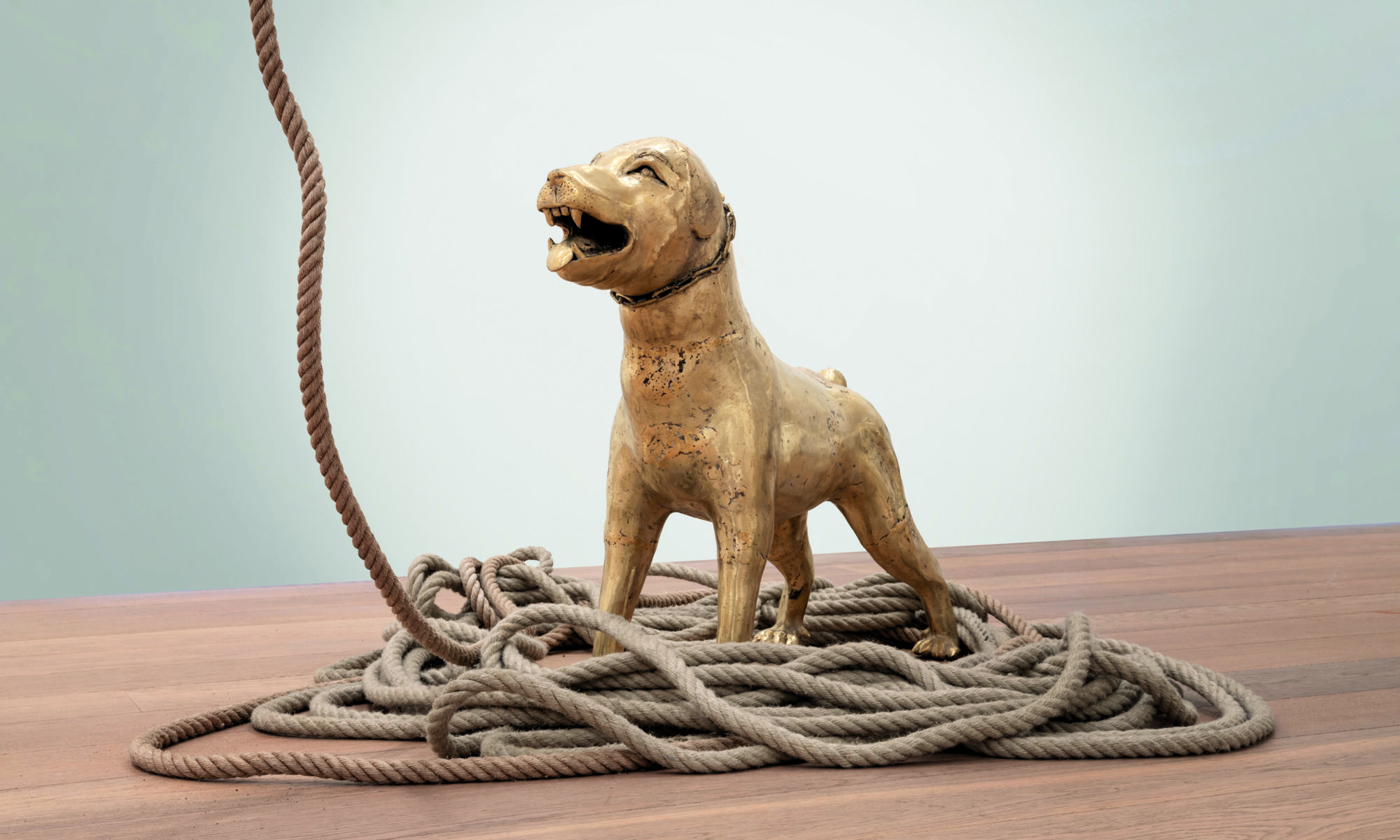 sculpture de chien avec corde sur fond gris